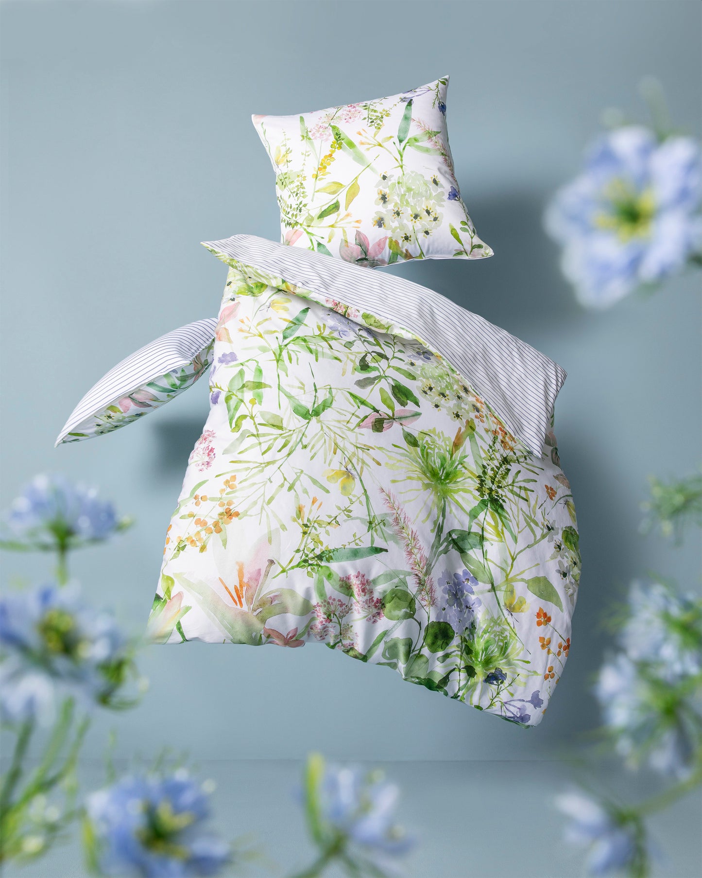 Ein Bettbezug-Set aus mehreren Kopfkissen und einer Bettdecke bezogen mit Mako-Satin Bettwaesche aus 100 Prozent Baumwolle mit Muster aus Blumen in der Farbe Weiss. Modell Summer.