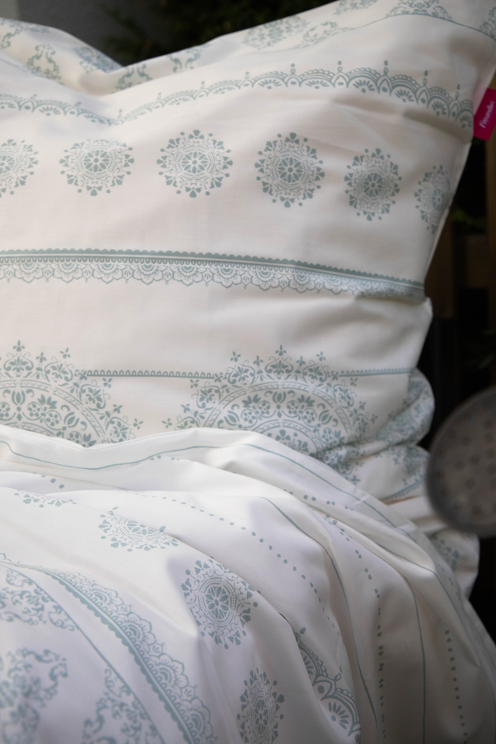 Detaildarstellung der geografischen Formen auf Kopfkissen und Bettdecke der Mako-Satin Bettwaesche Modell Freundin Home Collection Mint.