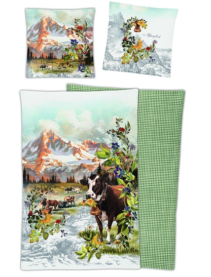 Zwei Kopfkissen und eine Bettdecke bezogen mit Mako-Satin Bettwaesche mit einem Muster aus Alpenlandschaft in der Farbe Gruen. Modell Magic Alpenglueck.