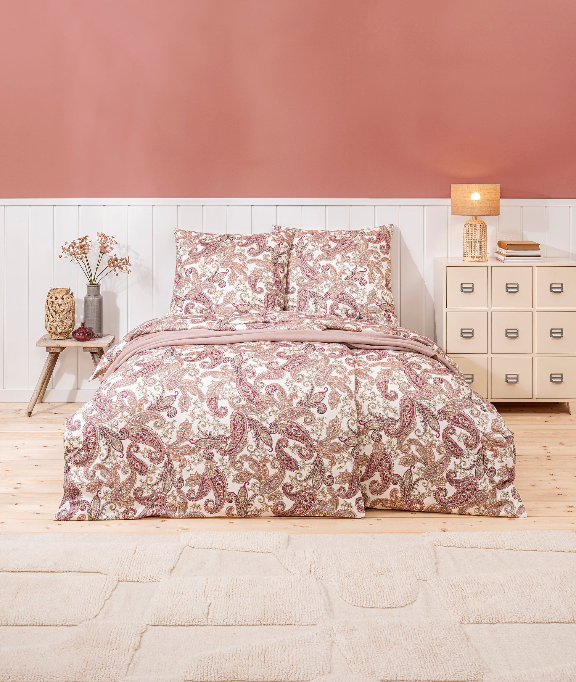 Ein Bettbezug-Set aus mehreren Kopfkissen und einer Bettdecke bezogen mit Mako-Interlock-Jersey Bettwaesche aus 100 Prozent Baumwolle mit Muster aus Blueten in der Farbe Koralle. Modell Amadeus Koralle.