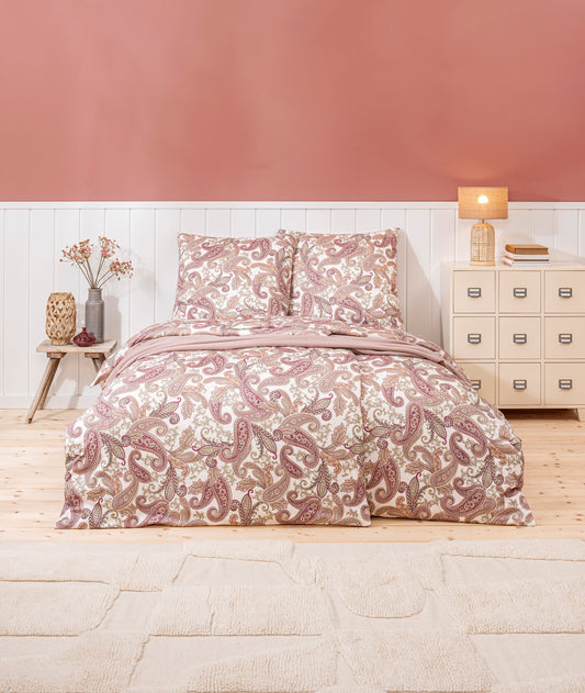 Ein Bettbezug-Set aus mehreren Kopfkissen und einer Bettdecke bezogen mit Mako-Interlock-Jersey Bettwaesche aus 100 Prozent Baumwolle mit Muster aus Blueten in der Farbe Koralle. Modell Amadeus Koralle.