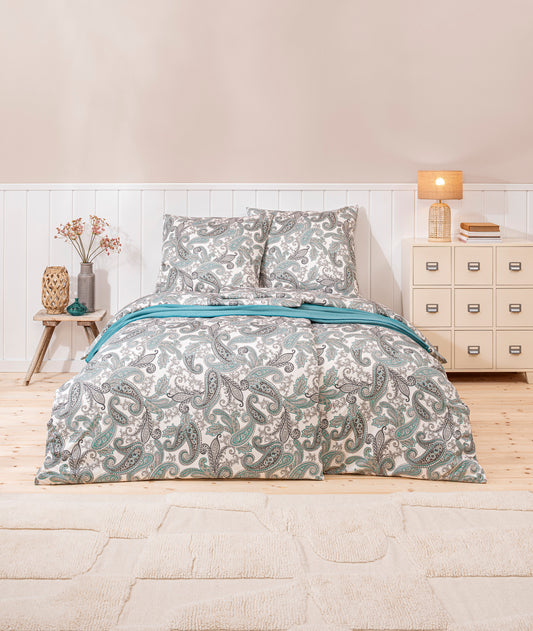 Ein Bettbezug-Set aus mehreren Kopfkissen und einer Bettdecke bezogen mit Mako-Interlock-Jersey Bettwaesche aus 100 Prozent Baumwolle mit Muster aus Blueten in der Farbe Mint. Modell Amadeus Mint.