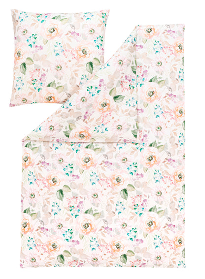 Ein Kopfkissen und eine Bettdecke bezogen mit Mako-Interlock-Jersey Bettwaesche mit einem Muster aus Blumen in der Farbe Rosa. Modell Britta Puder.