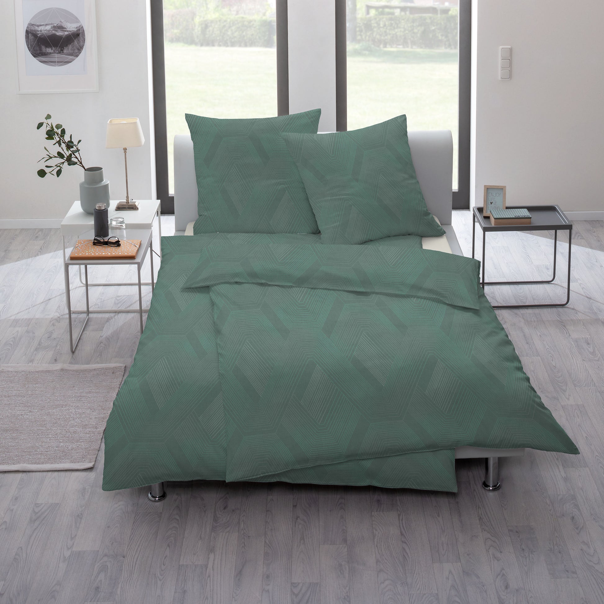 Ein Bettbezug-Set aus mehreren Kopfkissen und einer Bettdecke bezogen mit Mako-Interlock-Jersey Bettwaesche aus 100 Prozent Baumwolle mit Muster aus Rauten in der Farbe Gruen. Modell Emerald.