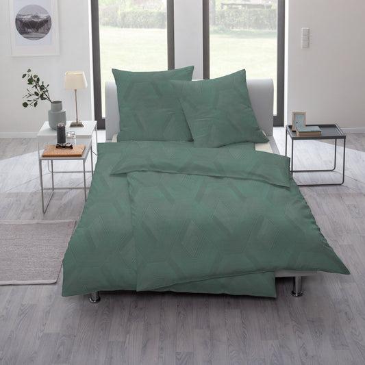 Ein Bettbezug-Set aus mehreren Kopfkissen und einer Bettdecke bezogen mit Mako-Interlock-Jersey Bettwaesche aus 100 Prozent Baumwolle mit Muster aus Rauten in der Farbe Gruen. Modell Emerald.