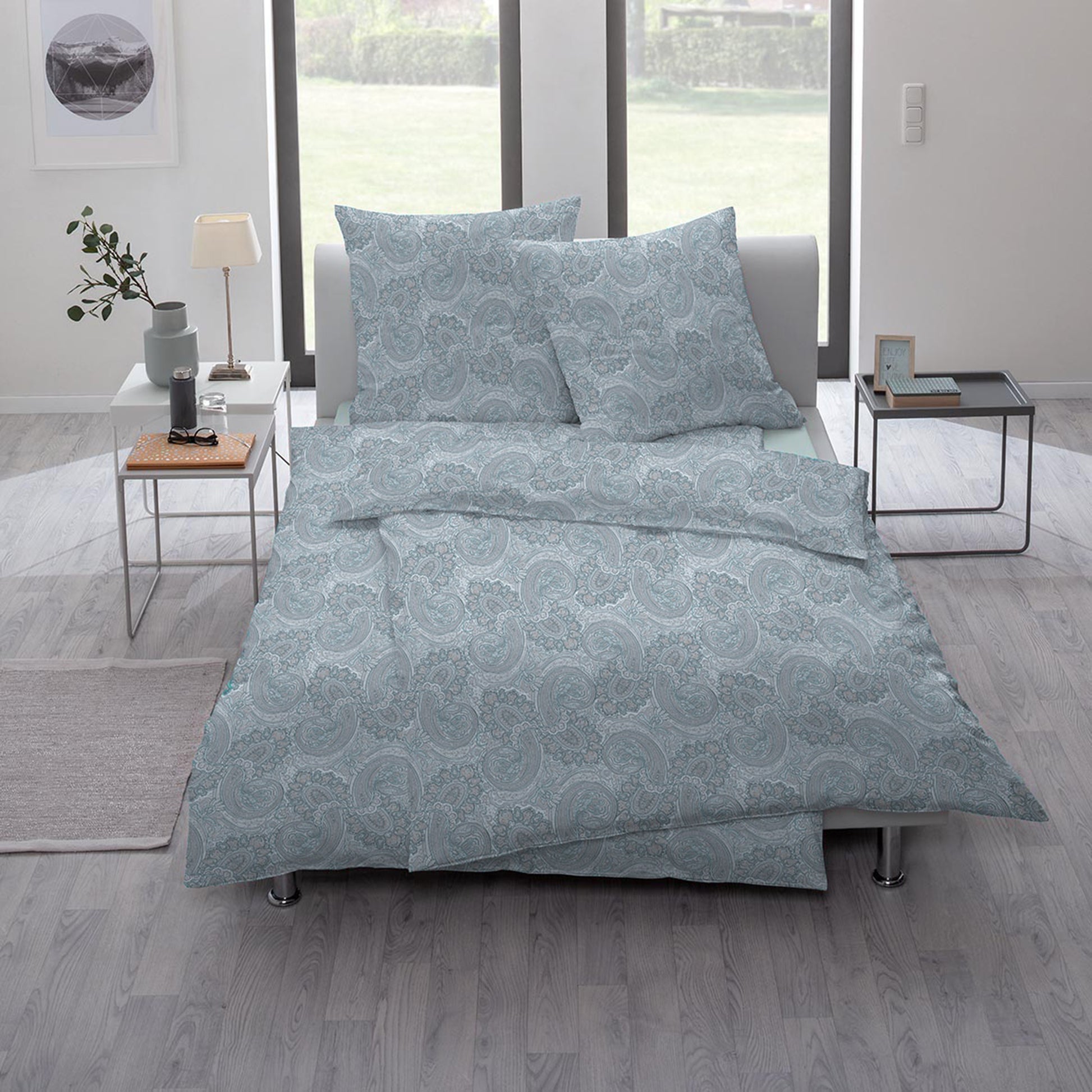 Ein Bettbezug-Set aus mehreren Kopfkissen und einer Bettdecke bezogen mit Mako-Interlock-Jersey Bettwaesche aus 100 Prozent Baumwolle mit Muster aus Ornamenten in der Farbe Blau. Modell Lipari.