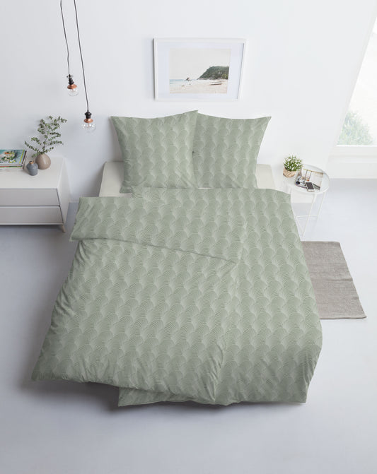 Ein Bettbezug-Set aus mehreren Kopfkissen und einer Bettdecke bezogen mit Mako-Interlock-Jersey Bettwaesche aus 100 Prozent Baumwolle mit Muster aus Muschel-Linien in der Farbe Gruen. Modell Pianosa.
