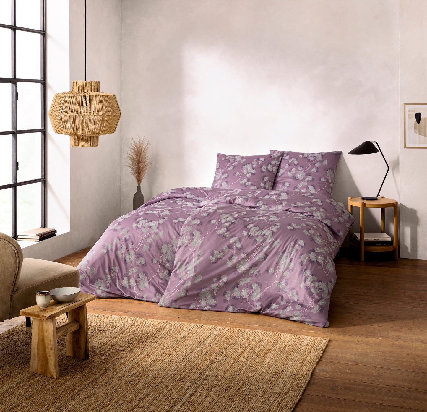 Ein Bettbezug-Set aus mehreren Kopfkissen und einer Bettdecke bezogen mit Mako-Interlock-Jersey Bettwaesche aus 100 Prozent Baumwolle mit Muster aus Blueten in der Farbe Rosa. Modell Rumi Mauve.