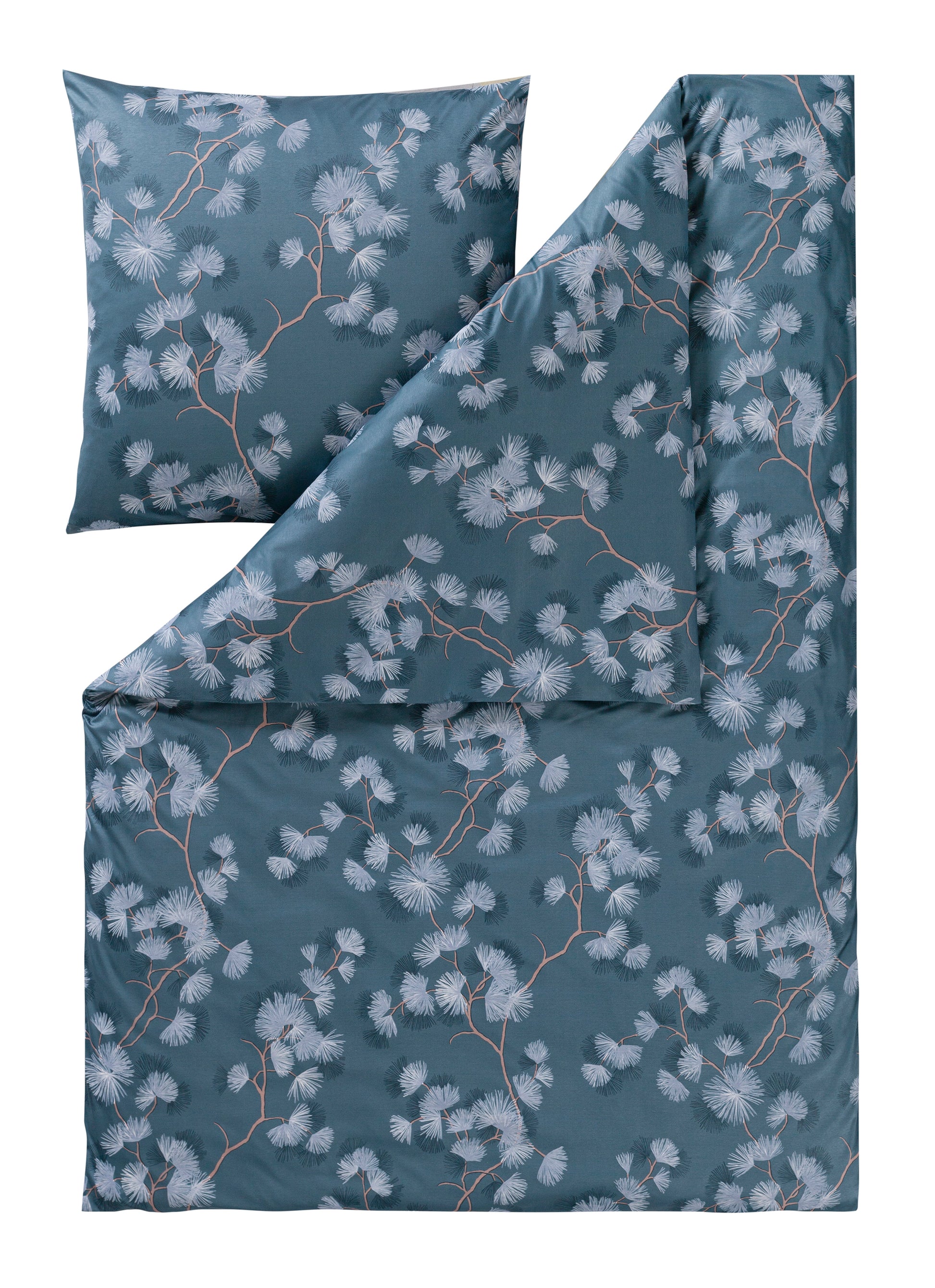 Ein Kopfkissen und eine Bettdecke bezogen mit Mako-Interlock-Jersey Bettwaesche mit einem Muster aus Blueten in der Farbe Blau. Modell Rumi Moos.