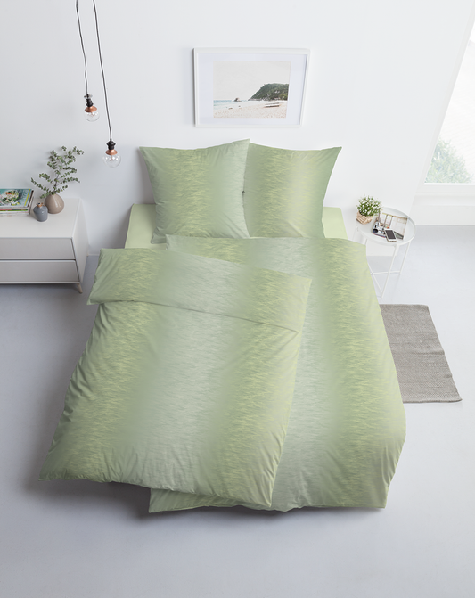 Ein Bettbezug-Set aus mehreren Kopfkissen und einer Bettdecke bezogen mit Mako-Interlock-Jersey Bettwaesche aus 100 Prozent Baumwolle mit Muster aus horizontalen Linien in der Farbe Gruen. Modell Salina.