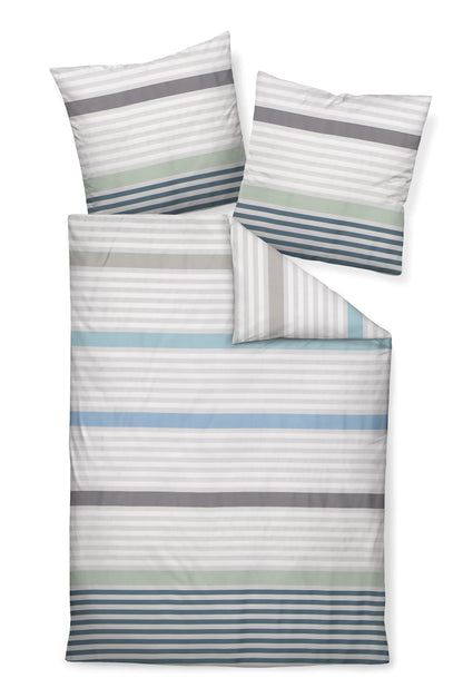 Zwei Kopfkissen und eine Bettdecke bezogen mit Mako-Satin Bettwaesche mit einem Muster aus horizontalen Streifen in der Farbe Mehrfarbig. Modell Perlblau Jade.