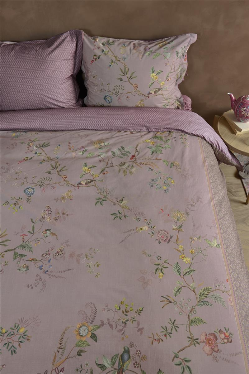 Ein Bettbezug-Set aus mehreren Kopfkissen und einer Bettdecke bezogen mit Perkal-Baumwoll Bettwaesche aus 100 Prozent Baumwolle mit Muster aus Pflanzen und Tieren in der Farbe Lila. Modell Autunno Lila.