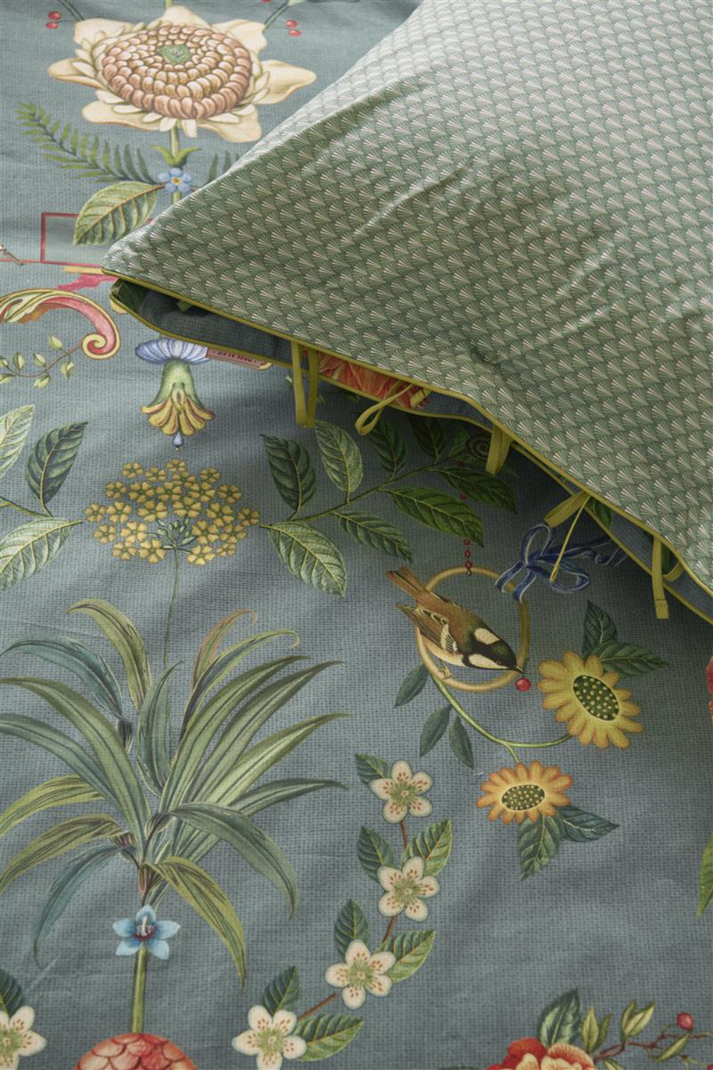 Detaildarstellung der Pflanzen und Tiere und grafischen Formen auf Kopfkissen und Bettdecke der Baumwolle Bettwaesche Modell Botanico Verde Blau.