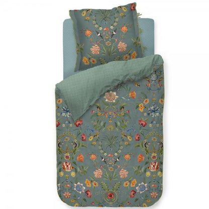 Ein Kopfkissen und eine Bettdecke bezogen mit Perkal-Baumwoll Bettwaesche mit einem Muster aus Pflanzen und Tieren und grafischen Formen in der Farbe Petrol. Modell Botanico Verde Blau.