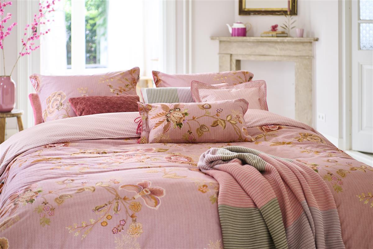 Auf einem Bett liegen mehrere Kopfkissen und eine Bettdecke bezogen mit Perkal-Baumwoll Bettwaesche aus 100 Prozent Baumwolle mit Muster aus Blumen und grafischen Formen in der Farbe Rosa. Modell Cece Fiore Rosa.