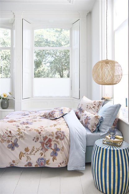 Auf einem Bett liegen mehrere Kopfkissen und eine Bettdecke bezogen mit Perkal-Baumwoll Bettwaesche aus 100 Prozent Baumwolle mit Muster aus Blumen in der Farbe Weiss. Modell Cece Fiore White.