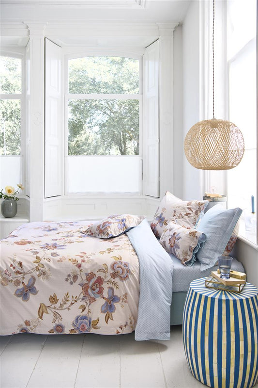 Auf einem Bett liegen mehrere Kopfkissen und eine Bettdecke bezogen mit Perkal-Baumwoll Bettwaesche aus 100 Prozent Baumwolle mit Muster aus Blumen in der Farbe Weiss. Modell Cece Fiore White.