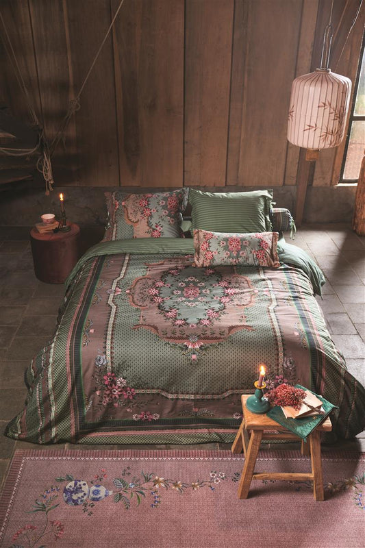 Auf einem Bett liegen mehrere Kopfkissen und eine Bettdecke bezogen mit Perkal-Baumwoll Bettwaesche aus 100 Prozent Baumwolle mit Muster aus Ornamenten in der Farbe Gruen. Modell Chique Green.