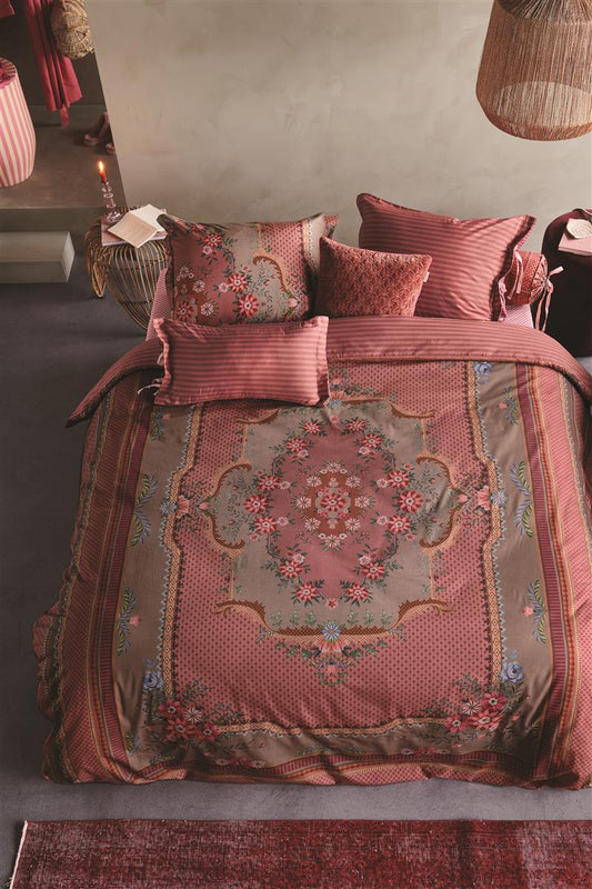 Auf einem Bett liegen mehrere Kopfkissen und eine Bettdecke bezogen mit Perkal-Baumwoll Bettwaesche aus 100 Prozent Baumwolle mit Muster aus Ornamenten in der Farbe Roségold. Modell Chique Pink.