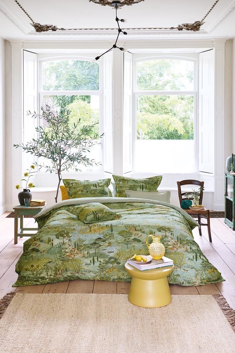 Auf einem Bett liegen mehrere Kopfkissen und eine Bettdecke bezogen mit Perkal-Baumwoll Bettwaesche aus 100 Prozent Baumwolle mit Muster aus Landschaft in der Toskana in der Farbe Gruen. Modell Toscana Gruen.