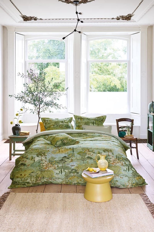 Auf einem Bett liegen mehrere Kopfkissen und eine Bettdecke bezogen mit Perkal-Baumwoll Bettwaesche aus 100 Prozent Baumwolle mit Muster aus Landschaft in der Toskana in der Farbe Gruen. Modell Toscana Gruen.