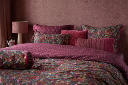 Auf einem Bett liegen mehrere Kopfkissen und eine Bettdecke bezogen mit Perkal-Baumwoll Bettwaesche aus 100 Prozent Baumwolle mit Muster aus Blumen in der Farbe Bordeaux. Modell Tutti i Fiori Dark Red.
