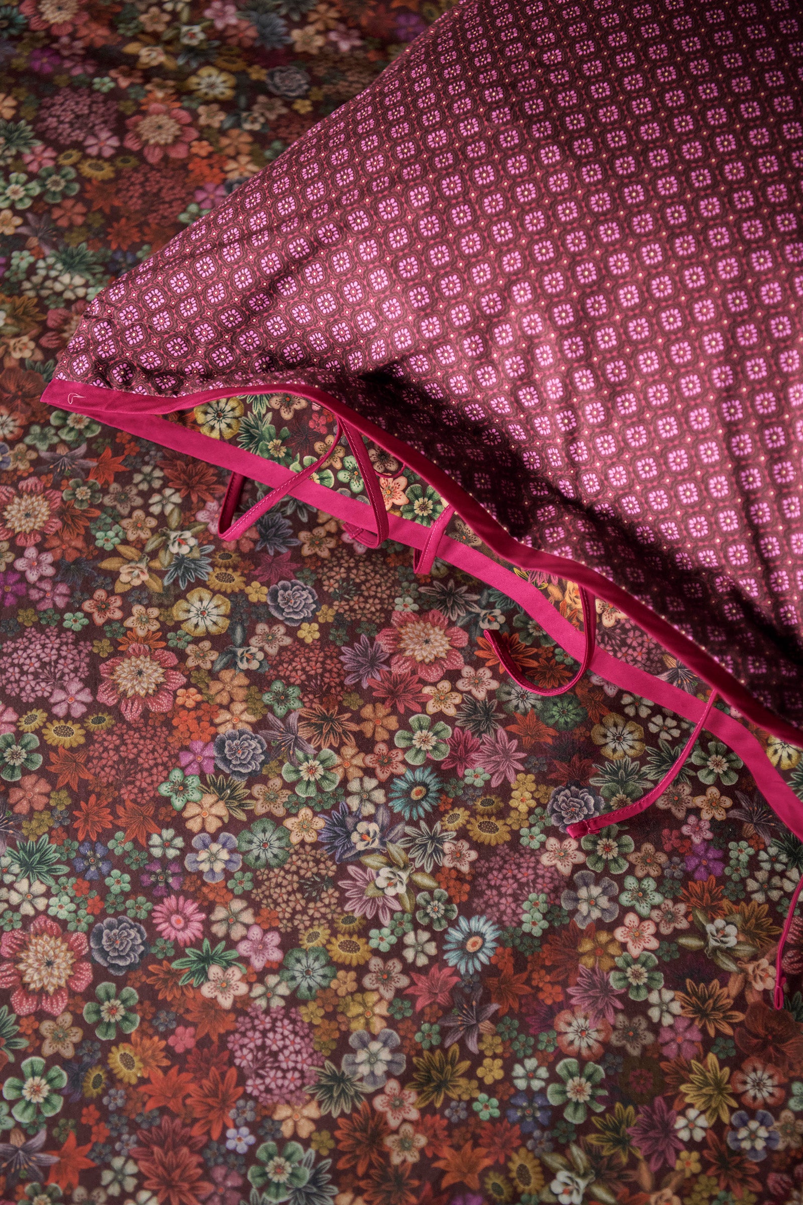 Detaildarstellung der Blumen auf Kopfkissen und Bettdecke der Perkal-Baumwoll Bettwaesche Modell Tutti i Fiori Dark Red.