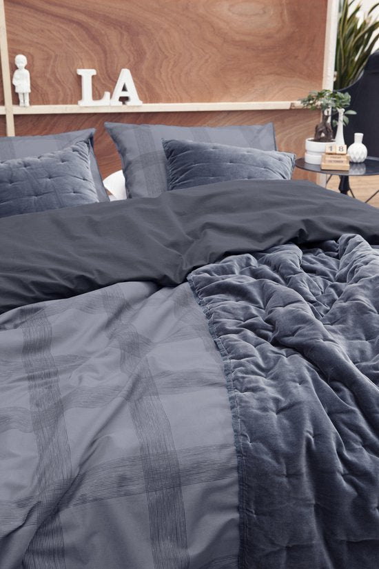 Auf einem Bett liegen mehrere Kopfkissen und eine Bettdecke bezogen mit Perkal-Baumwoll Bettwaesche aus 100 Prozent Baumwolle mit Muster aus Quadraten in der Farbe Grau. Modell Square Nights.