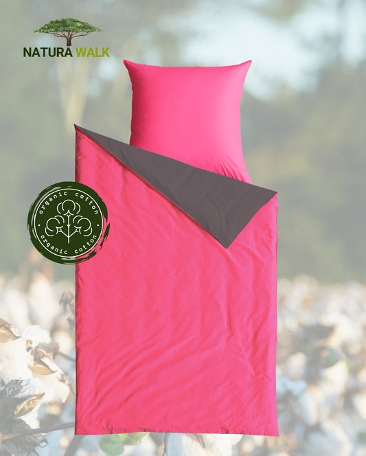 Ein Kopfkissen und eine Bettdecke bezogen mit Satin Bettwaesche in der Farbe Pink. Rueckseite Anthrazit. Modell Anthrazit/Cassis.