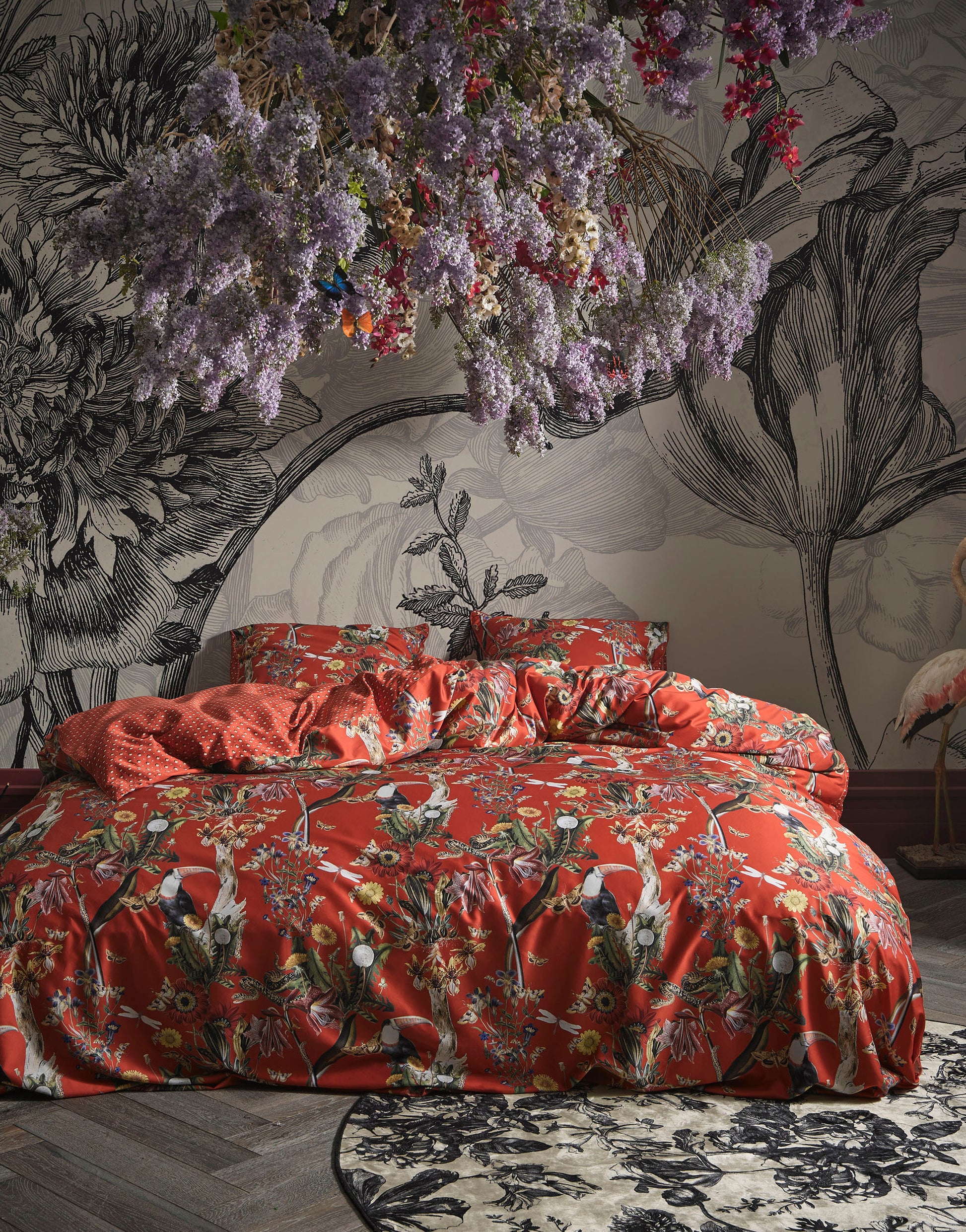 Ein Bettbezug-Set aus einem Kopfkissen und einer Bettdecke bezogen mit Satin Bettwaesche aus 100 Prozent Baumwolle mit Muster aus Blumen in der Farbe Rot. Modell Arien Chili.