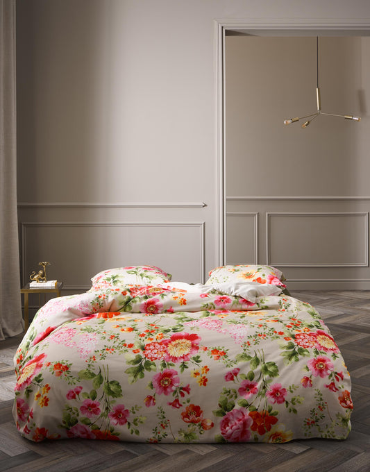 Ein Bettbezug-Set aus einem Kopfkissen und einer Bettdecke bezogen mit Satin Bettwaesche aus 100 Prozent Baumwolle mit Muster aus Blumen in der  Farbe Beige. Modell Claudia Stone.