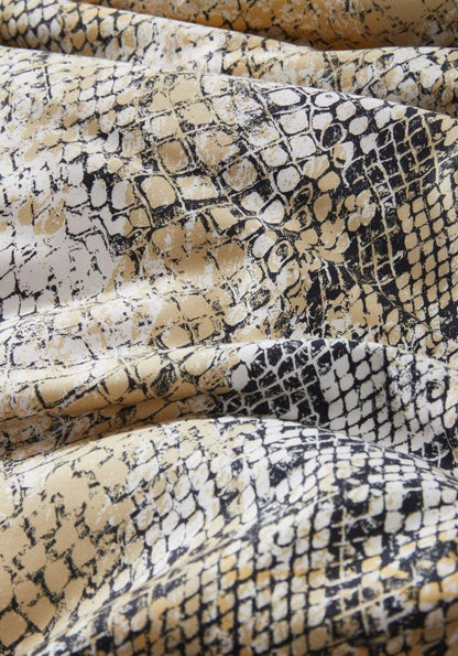 Detaildarstellung der Schlangenhaut der Essenza Satin Bettwaesche Modell Cleo Mustard.