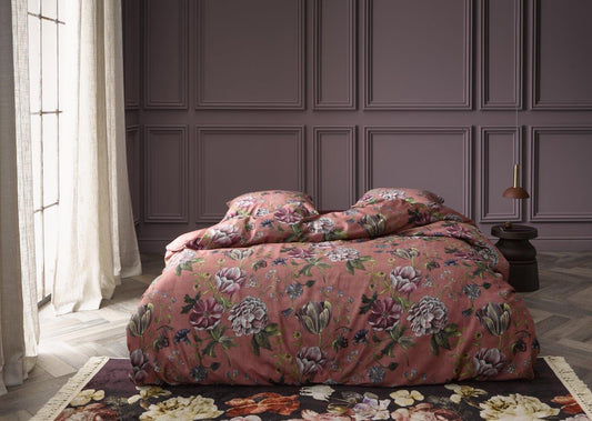 Ein Bettbezug-Set aus mehreren Kopfkissen und einer Bettdecke bezogen mit Satin Bettwaesche aus 100 Prozent Baumwolle mit Muster aus Blumen in der Farbe Roségold. Modell Elizabeth Rabarber.