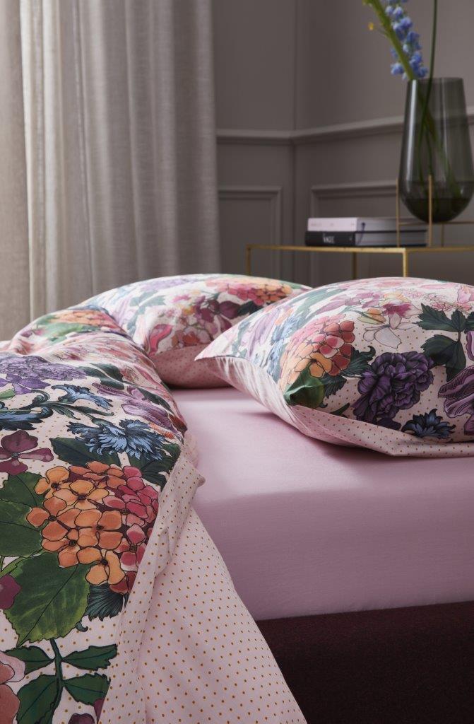 Detaildarstellung auf Kopfkissen und Bettdecke der Blumen der Essenza Satin Bettwaesche Modell Frida Multi.