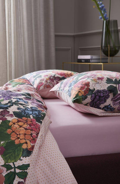 Detaildarstellung auf Kopfkissen und Bettdecke der Blumen der Essenza Satin Bettwaesche Modell Frida Multi.