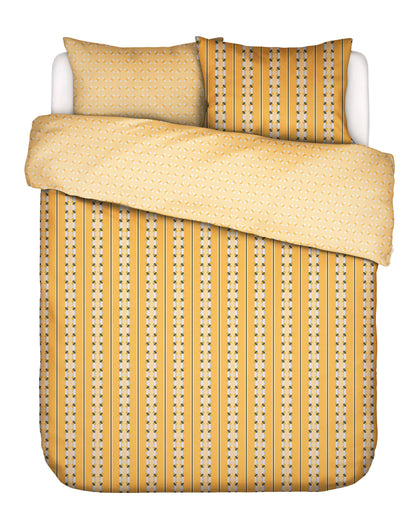 Zwei Kopfkissen und eine Bettdecke bezogen mit Satin Bettwaesche von Essenza mit einem Muster aus vertikalen Streifen in der Farbe Gelb. Modell Iva Ochre.