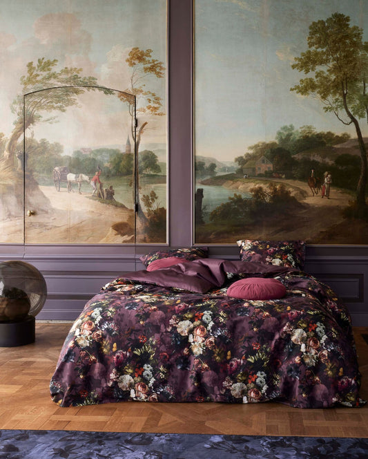 Ein Bettbezug-Set aus mehreren Kopfkissen und einer Bettdecke bezogen mit Satin Bettwaesche aus 100 Prozent Baumwolle mit Muster aus Blumen in der Farbe Lila. Modell Karli Purple Tulip.