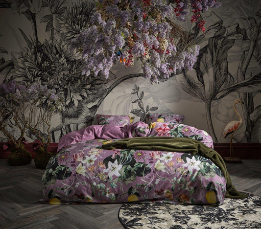 Ein Bettbezug-Set aus mehreren Kopfkissen und einer Bettdecke bezogen mit Satin Bettwaesche aus 100 Prozent Baumwolle mit Muster aus Blumen in der Farbe Lila. Modell Mary Lilac.