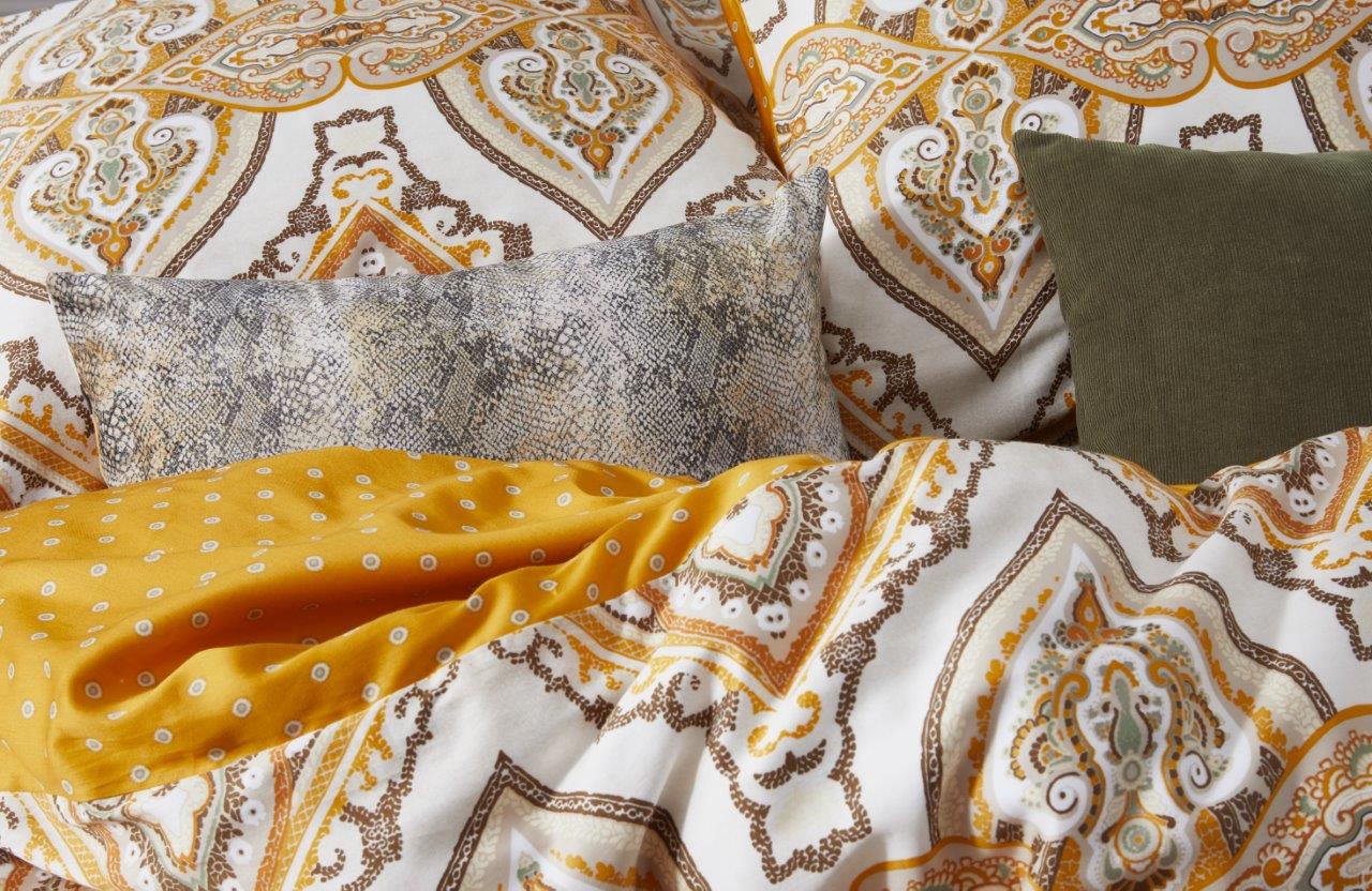 Detaildarstellung auf Kopfkissen und Bettdecke der Ornamente und Punkten der Essenza Satin Bettwaesche Modell Penelope Mustard.