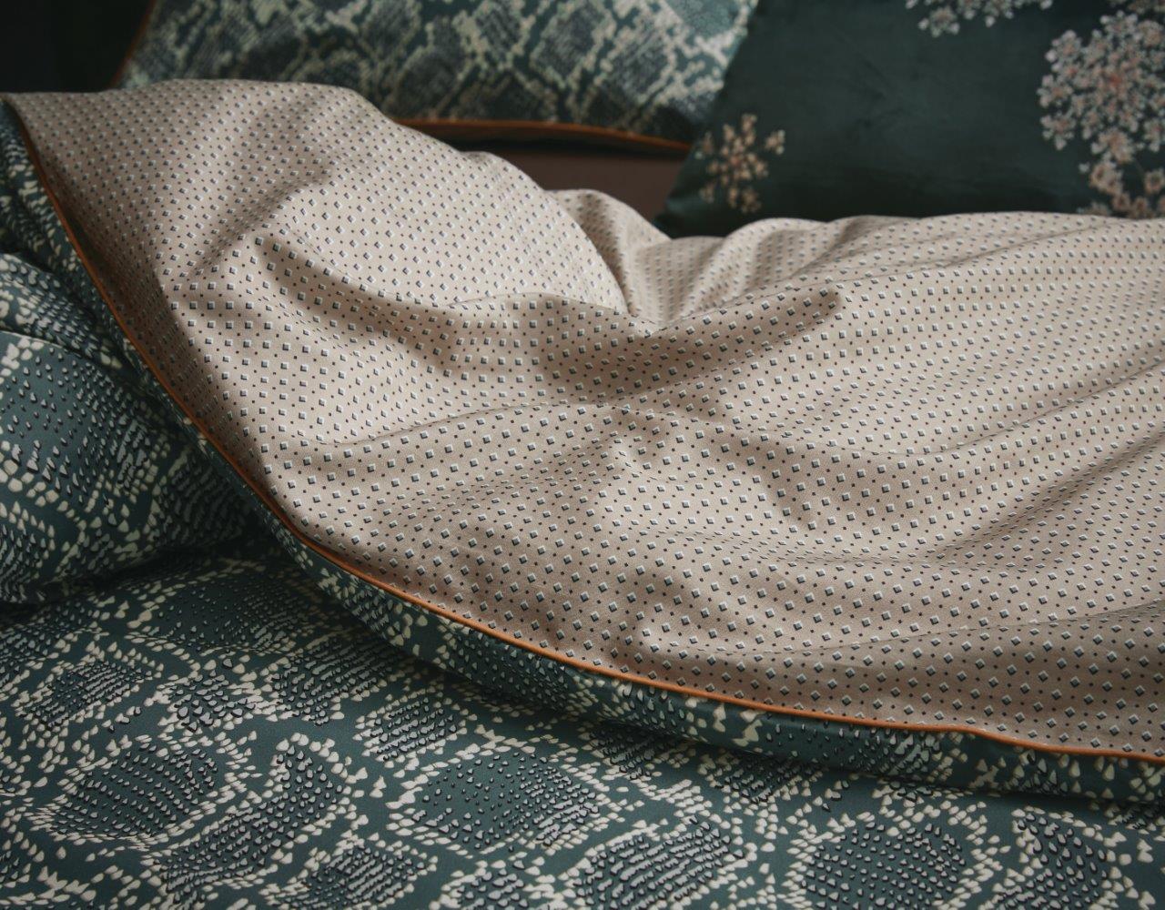 Detaildarstellung auf Kopfkissen und Bettdecke der Essenza Satin Bettwaesche Modell Solan Green.