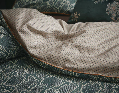 Detaildarstellung auf Kopfkissen und Bettdecke der Essenza Satin Bettwaesche Modell Solan Green.