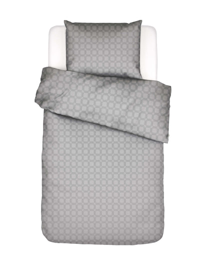 Ein Kopfkissen und eine Bettdecke bezogen mit Satin Bettwaesche von Essenza mit einem Muster aus Vierecken und Rauten in der Farbe Grau. Modell Teada Grey.