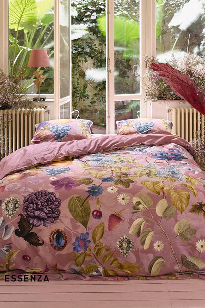 Ein Bettbezug-Set aus mehreren Kopfkissen und einer Bettdecke bezogen mit Satin Bettwaesche aus 100 Prozent Baumwolle mit Muster aus Pflanzen in der Farbe Rosa. Modell Veronique Woodrose.