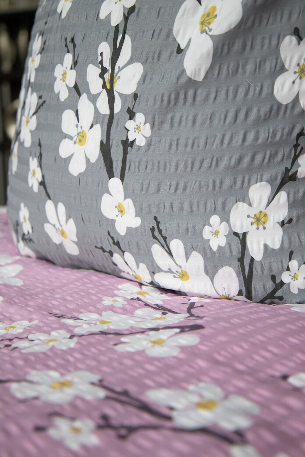 Detaildarstellung der Blueten auf Kopfkissen und Bettdecke der Satin-Seersucker Bettwaesche Modell Grau.