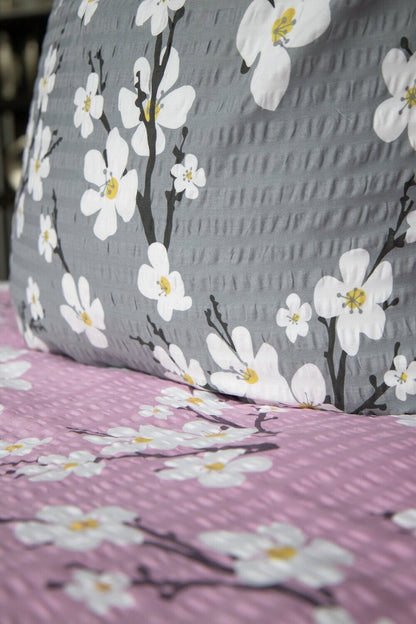 Detaildarstellung der Blueten auf Kopfkissen und Bettdecke der Satin-Seersucker Bettwaesche Modell Grau.