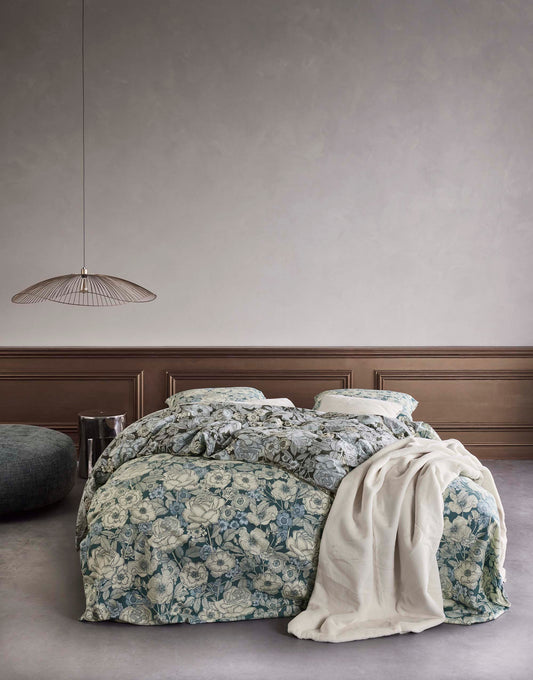 Ein Bettbezug-Set aus mehreren Kopfkissen und einer Bettdecke bezogen mit Twill-Baumwoll Bettwaesche aus 100 Prozent Baumwolle mit Muster aus Blumen in der Farbe Tuerkis. Modell Camille Reef Green.