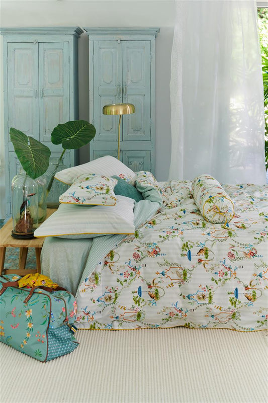 Auf einem Bett liegen mehrere Kopfkissen und eine Bettdecke bezogen mit Perkal-Baumwoll Bettwaesche aus 100 Prozent Baumwolle mit Muster aus Pflanzen in der Farbe Weiss. Modell Singerie White.