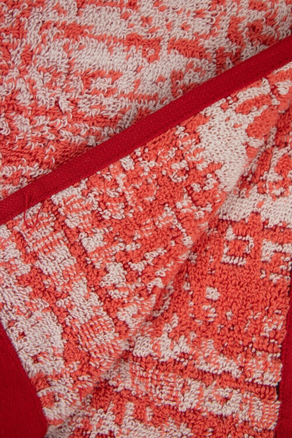 Eine Detailaufnahme von mehreren Handtuechern die aufeinander liegen in der Farbe Rot. Die Struktur wird hervorgehoben. Modell Mivu Cayenne.