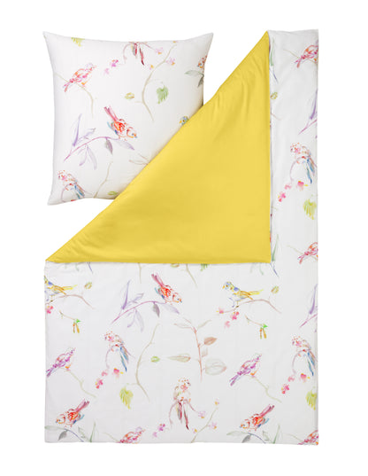 Ein Kopfkissen und eine Bettdecke bezogen mit Mako-Satin Bettwaesche mit einem Muster aus Voegeln in der Farbe Gelb. Modell Sparrow.