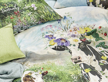 Detaildarstellung der Kuehe auf einer Wiese auf Kopfkissen und Bettdecke der Mako-Satin Bettwaesche Modell Almwiese.